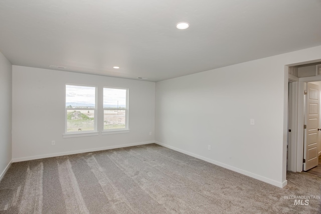 unfurnished room with recessed lighting, light colored carpet, and baseboards