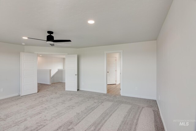 unfurnished bedroom featuring light carpet, ceiling fan, recessed lighting, and baseboards