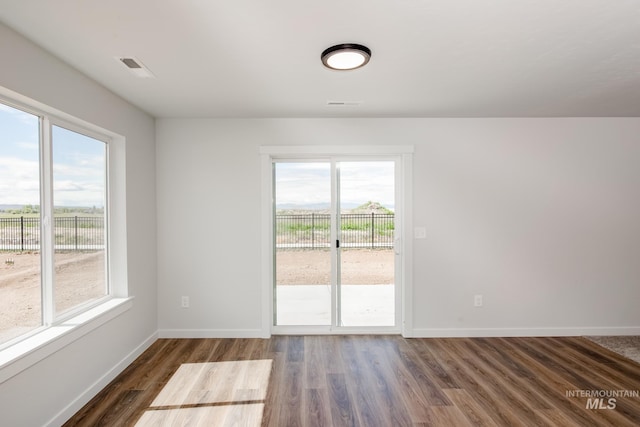 empty room with dark wood finished floors and baseboards