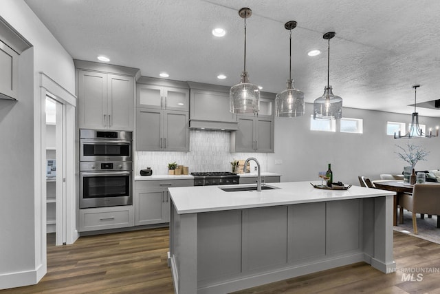 kitchen with double oven, gray cabinets, sink, and pendant lighting