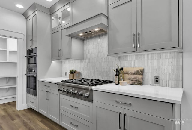 kitchen featuring backsplash, stainless steel appliances, dark wood-type flooring, and gray cabinetry