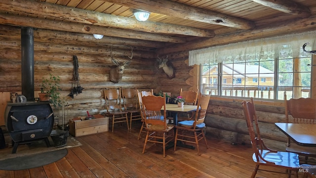 2742 Dixie Rd, Dixie, ID 83525 - dining space with beamed ceiling, wood-type flooring, a wood stove, log walls, and wooden ceiling