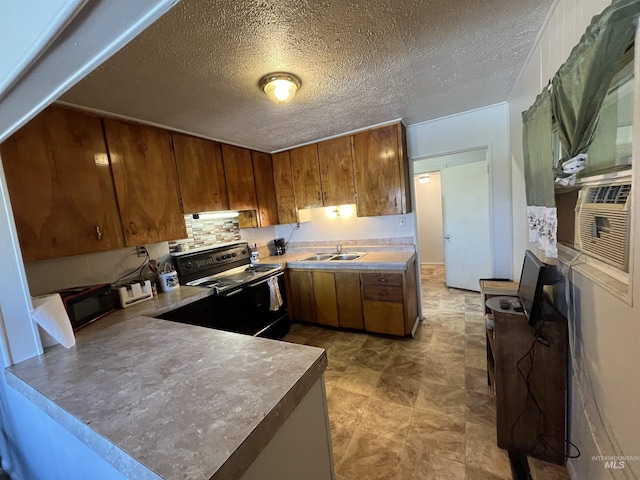 2131 N 2900 W, Arco, ID 83213 - kitchen featuring black appliances, a peninsula, a sink, and brown cabinets
