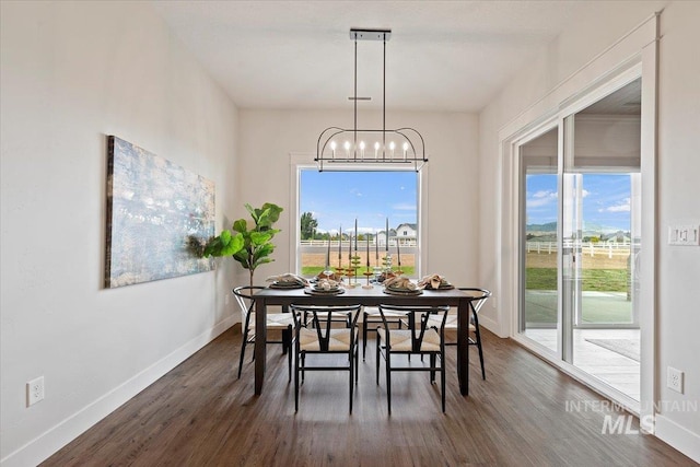 dining area with a chandelier, a healthy amount of sunlight, and dark hardwood / wood-style flooring