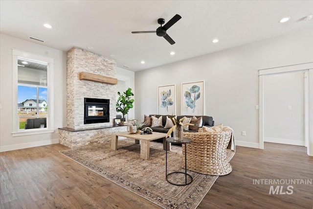 living room featuring wood-type flooring, a fireplace, and ceiling fan