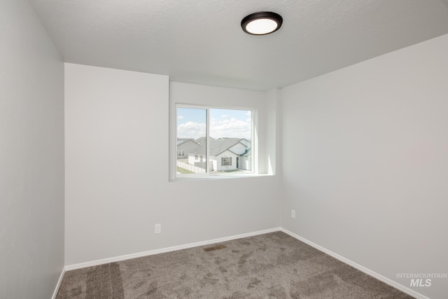 carpeted spare room featuring a textured ceiling