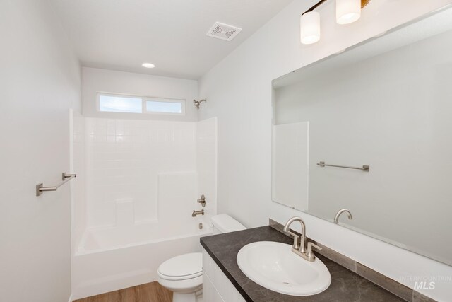 full bathroom featuring shower / tub combination, vanity, hardwood / wood-style flooring, and toilet