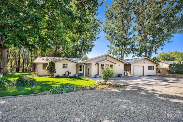 ranch-style house featuring a front lawn and a garage