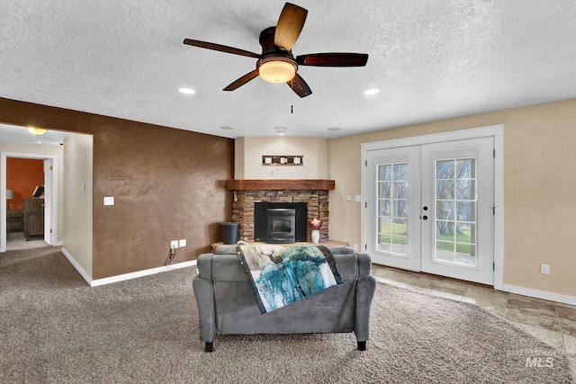 carpeted living room featuring a textured ceiling, ceiling fan, and french doors