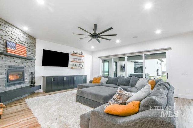 living room featuring a fireplace, hardwood / wood-style floors, and ceiling fan