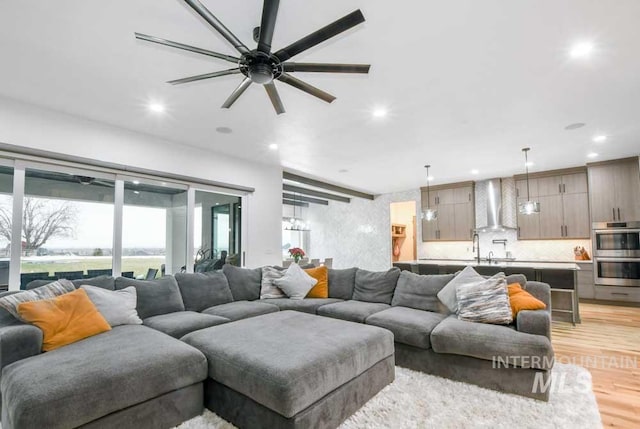 living room featuring ceiling fan and light hardwood / wood-style flooring