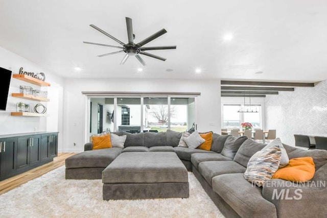 living room with ceiling fan and light hardwood / wood-style flooring