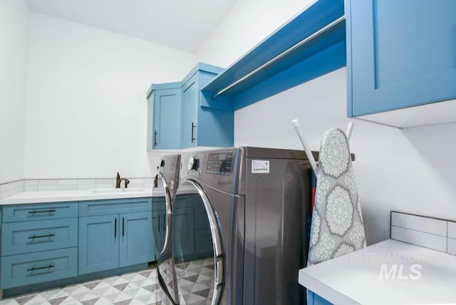 laundry room with washer and clothes dryer, sink, and cabinets