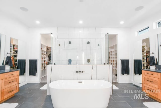 bathroom featuring plus walk in shower, tile walls, tile patterned flooring, and vanity