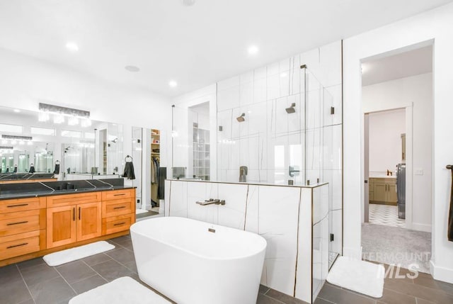 bathroom featuring independent shower and bath, vanity, and tile patterned flooring