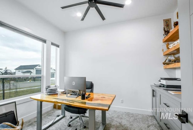 carpeted office space featuring ceiling fan