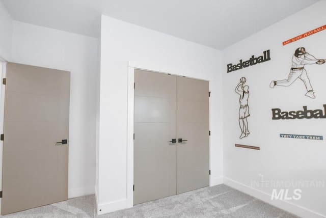 unfurnished bedroom featuring light colored carpet and a closet