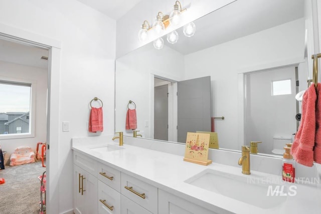 bathroom with a healthy amount of sunlight, vanity, and toilet