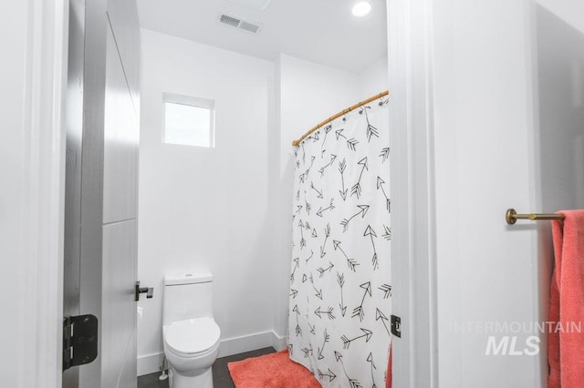 bathroom featuring walk in shower, toilet, and tile patterned floors