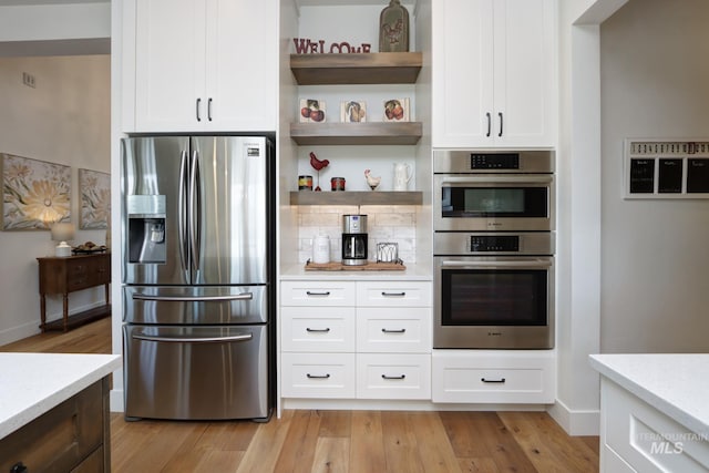 kitchen with open shelves, appliances with stainless steel finishes, light wood-style flooring, and white cabinetry