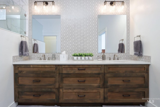 full bath with a sink, tasteful backsplash, and double vanity