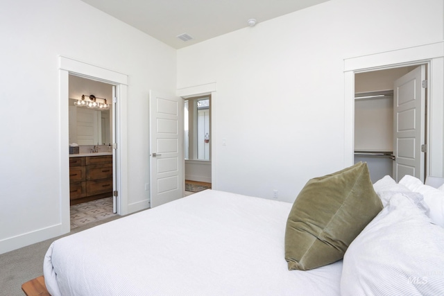 bedroom with visible vents, a sink, connected bathroom, carpet flooring, and baseboards