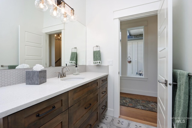 bathroom featuring baseboards, vanity, and an inviting chandelier