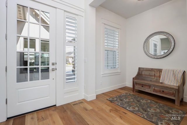 entryway featuring visible vents, baseboards, and wood finished floors