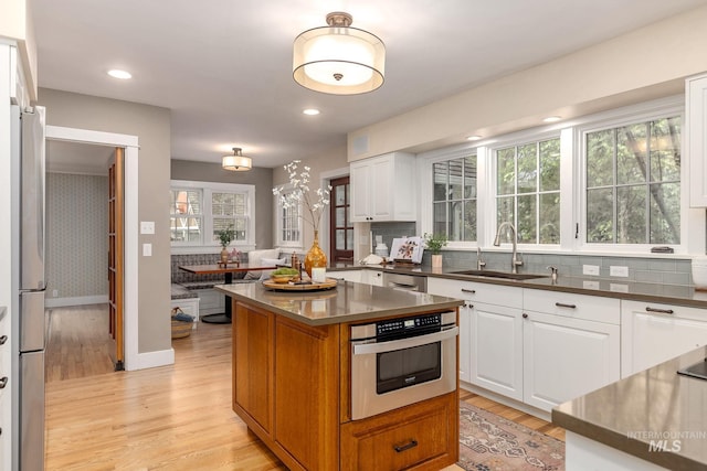 1919 N 21st St, Boise, ID 83702 - kitchen with a sink, stainless steel appliances, dark countertops, light wood finished floors, and white cabinetry