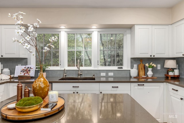 1919 N 21st St, Boise, ID 83702 - kitchen with a sink, dark countertops, backsplash, and white cabinetry