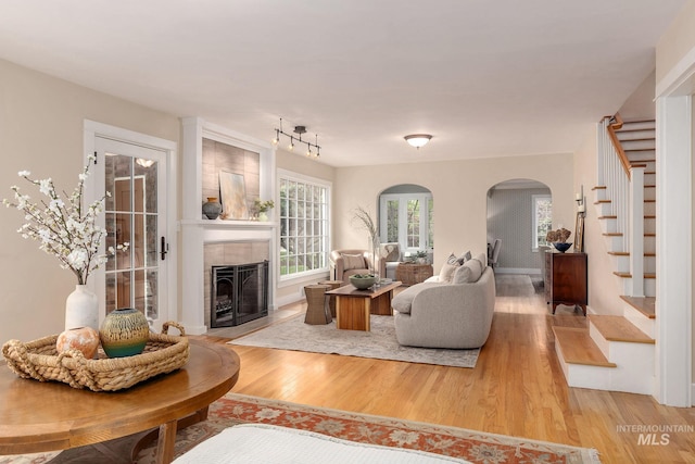 1919 N 21st St, Boise, ID 83702 - living room featuring stairs, arched walkways, light wood-type flooring, and a tile fireplace