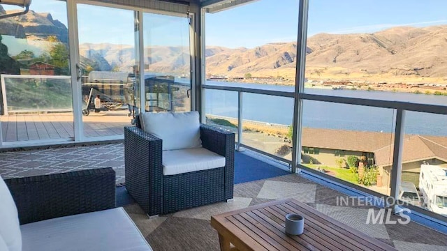 sunroom / solarium with a water and mountain view