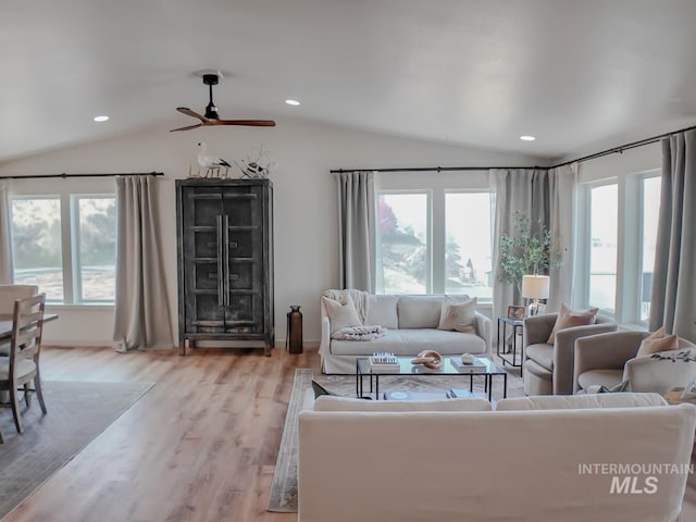 living room featuring ceiling fan, light hardwood / wood-style floors, and lofted ceiling