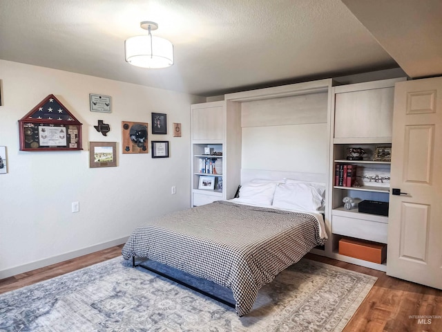 bedroom with dark hardwood / wood-style flooring and a textured ceiling