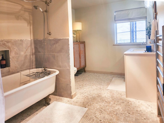 bathroom with vanity, tile walls, and toilet