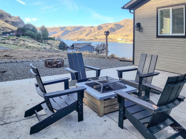 view of patio with a mountain view and an outdoor fire pit