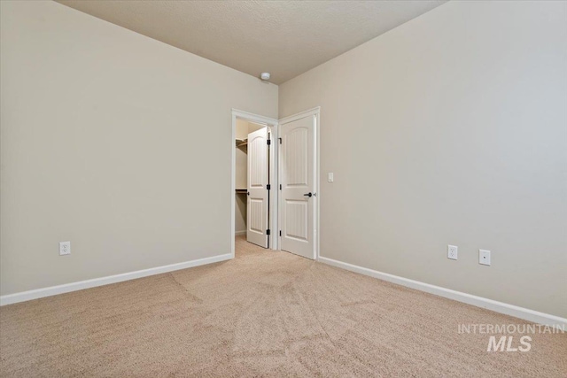 carpeted spare room with baseboards and a textured ceiling