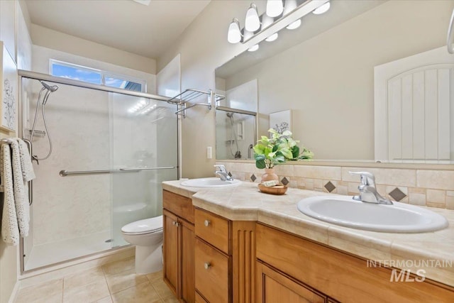 full bathroom with double vanity, a stall shower, and a sink