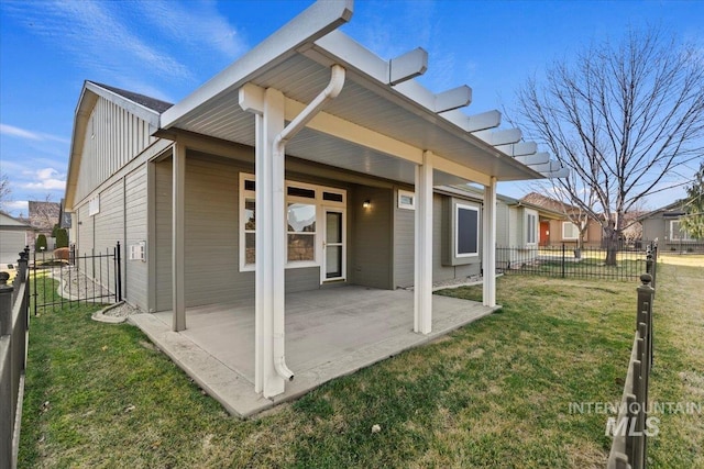 rear view of house with board and batten siding, a patio, fence, and a lawn