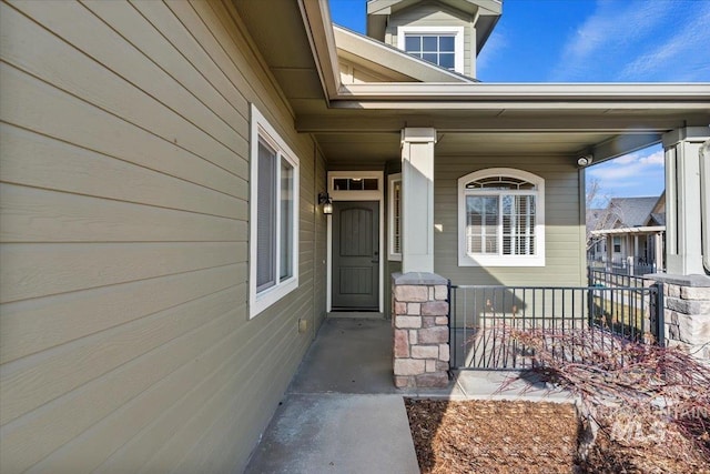 property entrance featuring a porch and fence