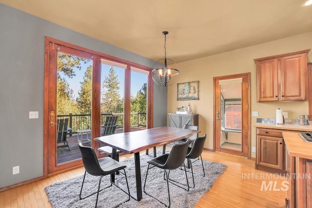 dining area featuring light hardwood / wood-style floors and an inviting chandelier