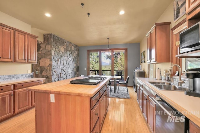 kitchen featuring stainless steel appliances, sink, a notable chandelier, a center island, and butcher block counters