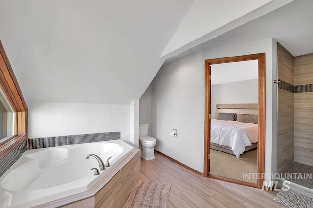 bathroom featuring toilet, shower with separate bathtub, and vaulted ceiling