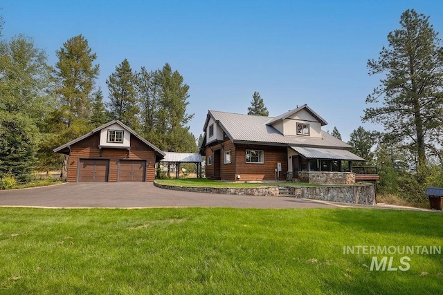 view of front of property with a front yard, a garage, and an outdoor structure