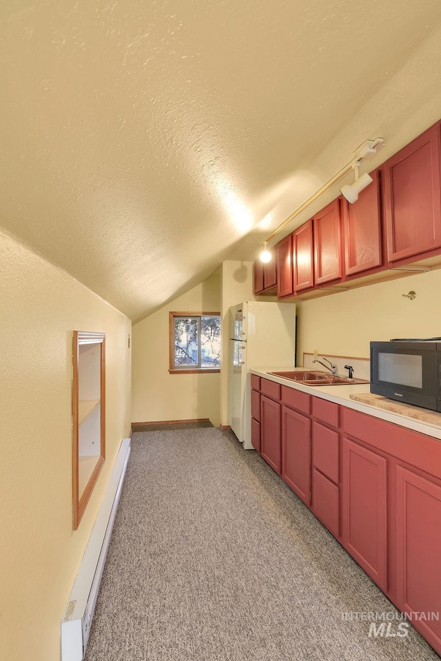 kitchen with a textured ceiling, sink, light colored carpet, and baseboard heating