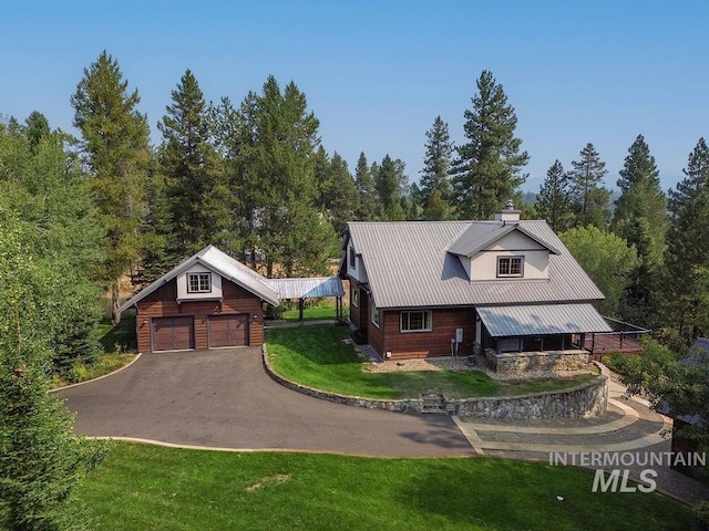 view of front of home with a front yard, an outbuilding, and a garage