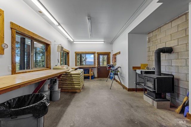 84 Jughandle Dr, Mccall, ID 83638 - miscellaneous room featuring concrete flooring, a wood stove, and a workshop area