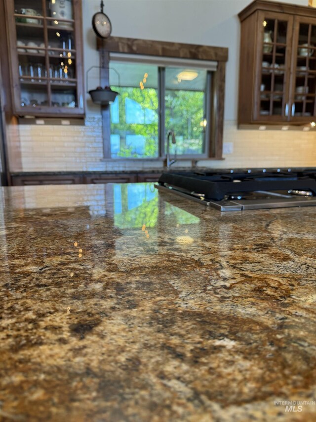 84 Jughandle Dr, Mccall, ID 83638 - kitchen featuring decorative backsplash, glass insert cabinets, dark stone countertops, and stainless steel gas cooktop