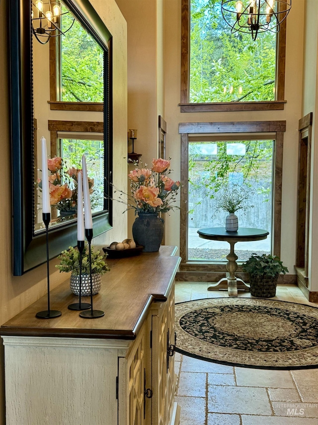 84 Jughandle Dr, Mccall, ID 83638 - entrance foyer with a chandelier, a towering ceiling, and stone tile flooring