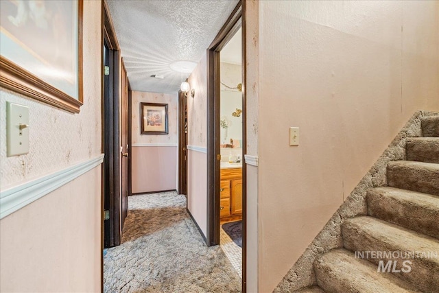 2503 Lyle Ct, Nampa, ID 83651 - corridor with light carpet, a textured ceiling, stairs, and a wainscoted wall